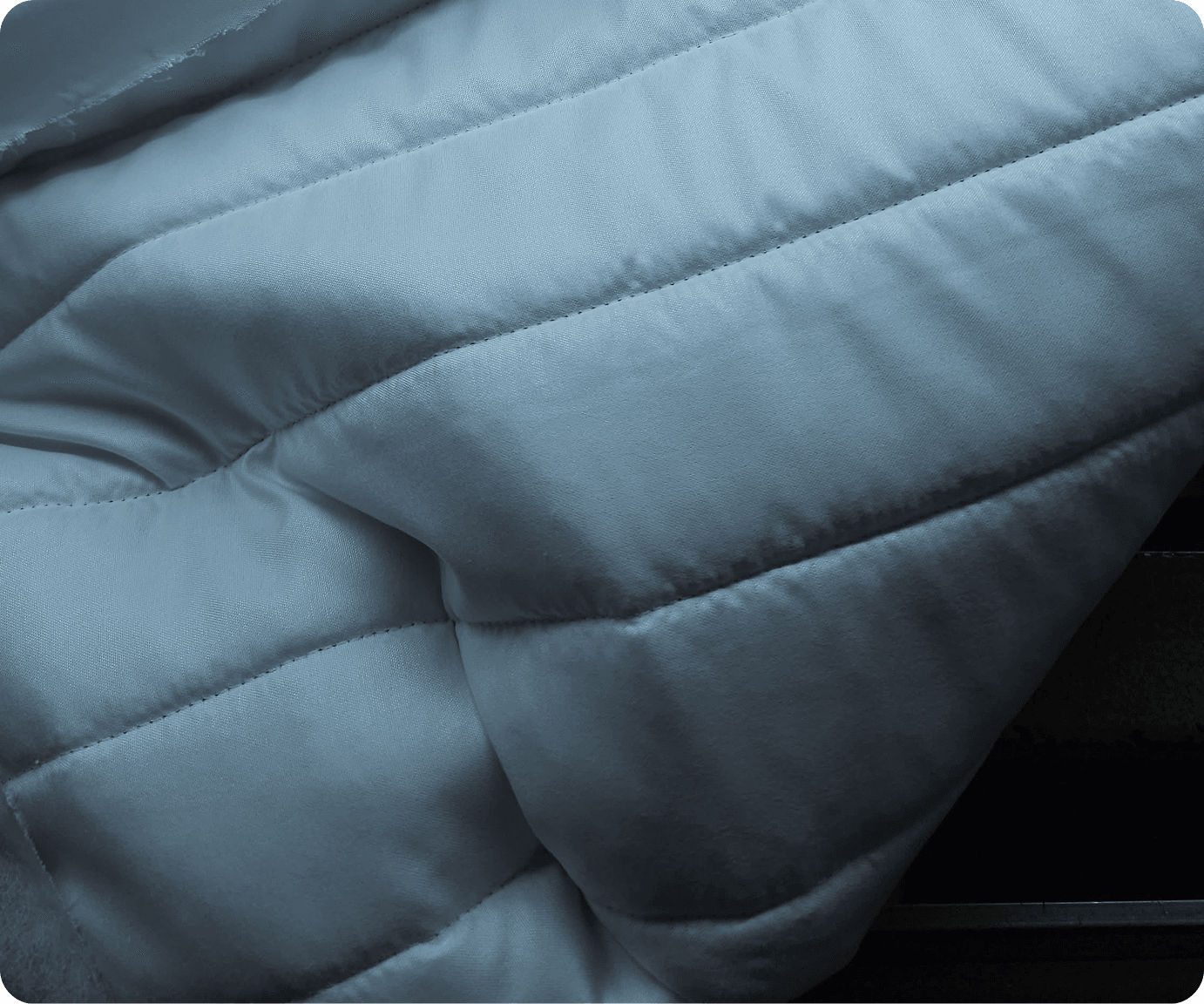 Close-up of pale blue channel-quilted padded fabric