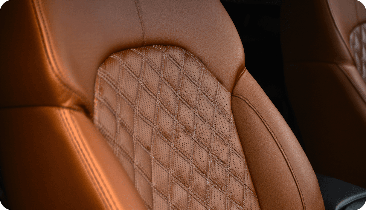 A tan leather car seat with a diamond-quilted centre panel