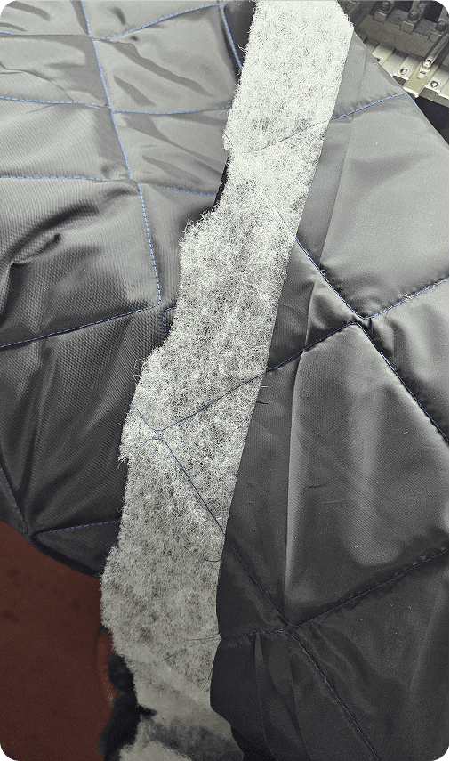 A quilted panel being drawn off the machine