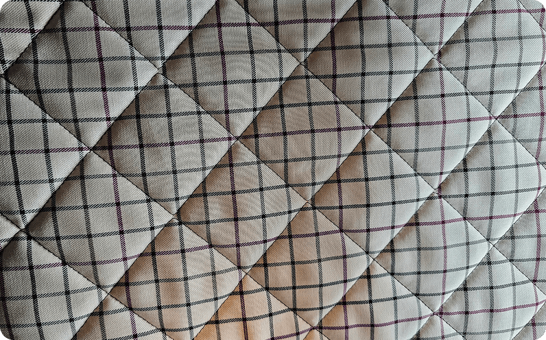 A diamond variation quilted in silver satin
