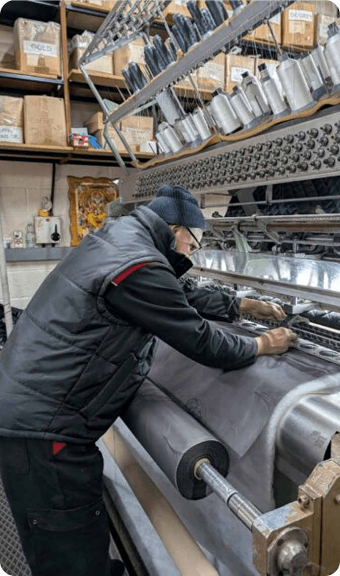 A machinist setting the needle bar on a quilting machine