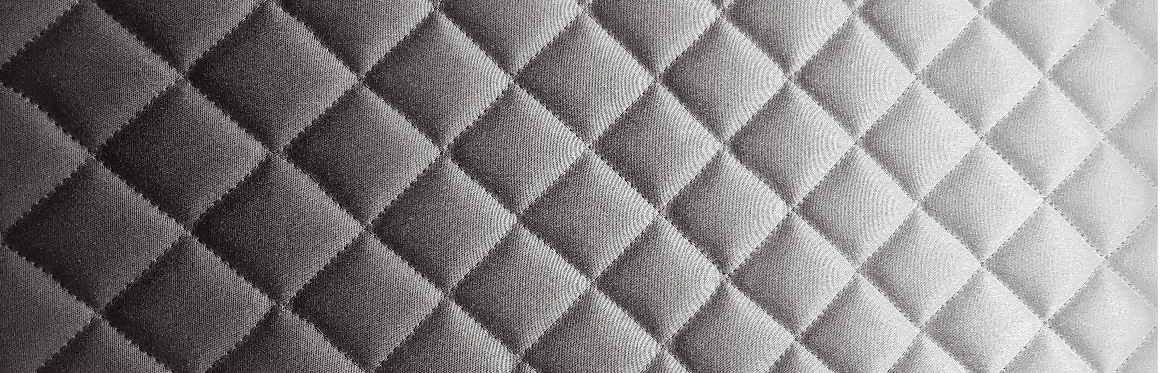 Diamond-quilted fabric shading from dark to light