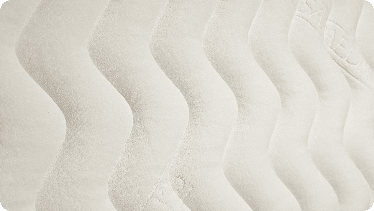 Close-up of cream quilted fabric with wavy vertical stitching