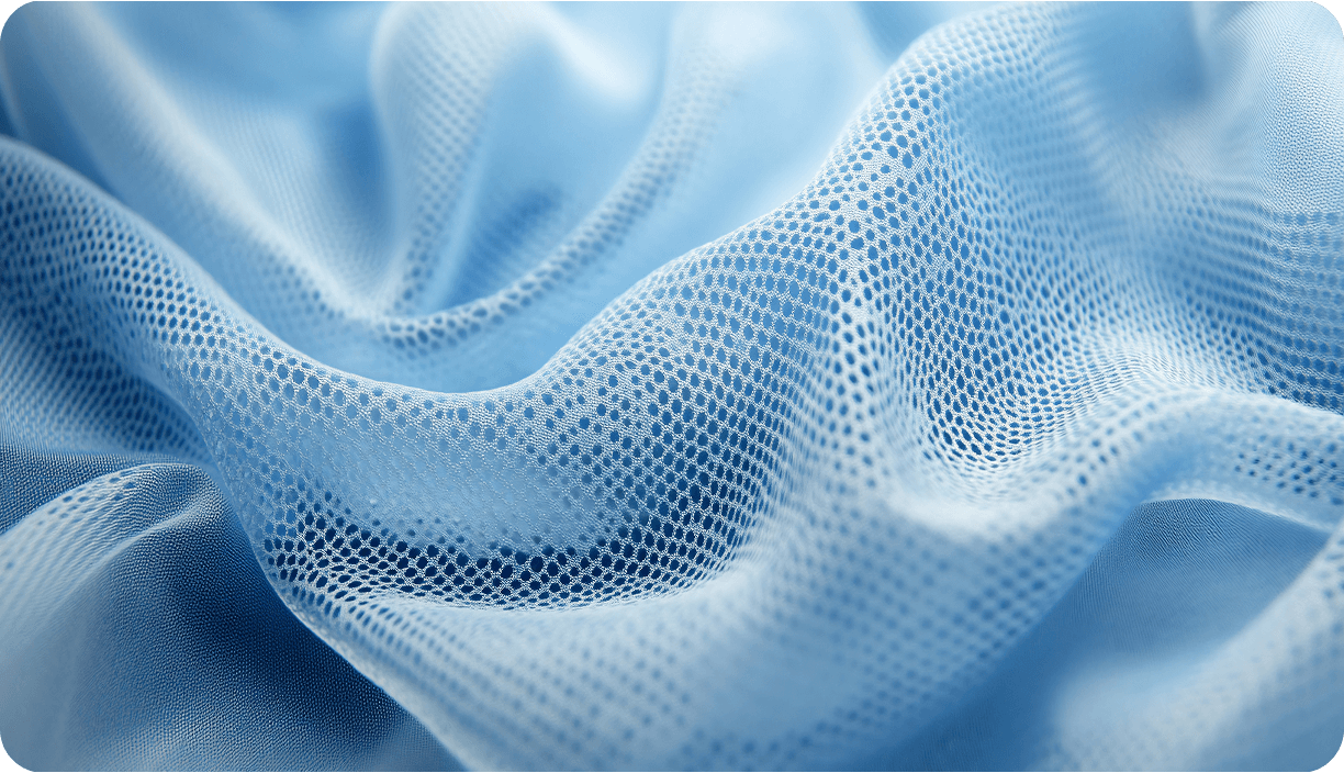 Folds of pale blue open-weave medical mesh fabric