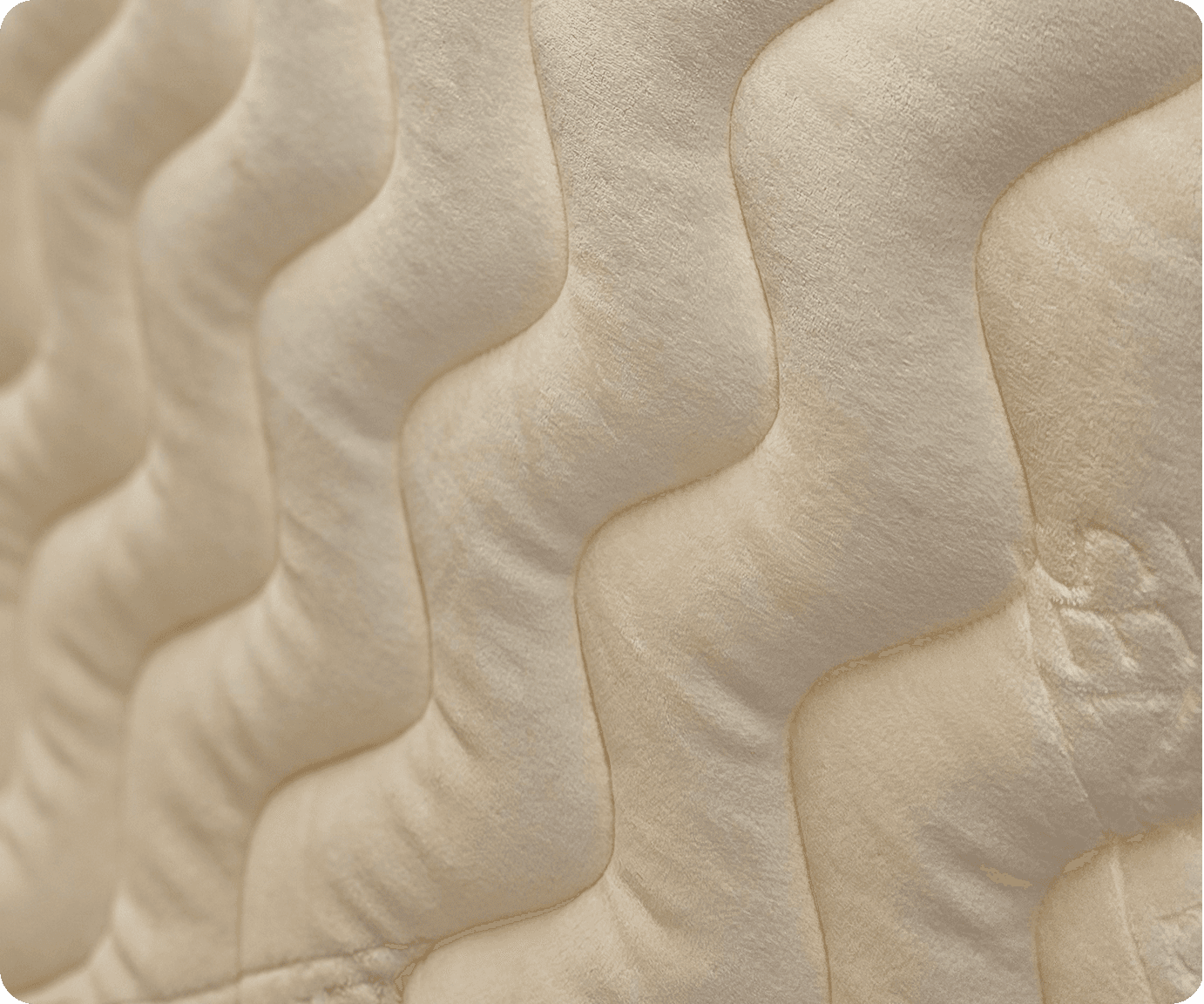 Close-up of cream quilted fabric with a wavy vertical stitch