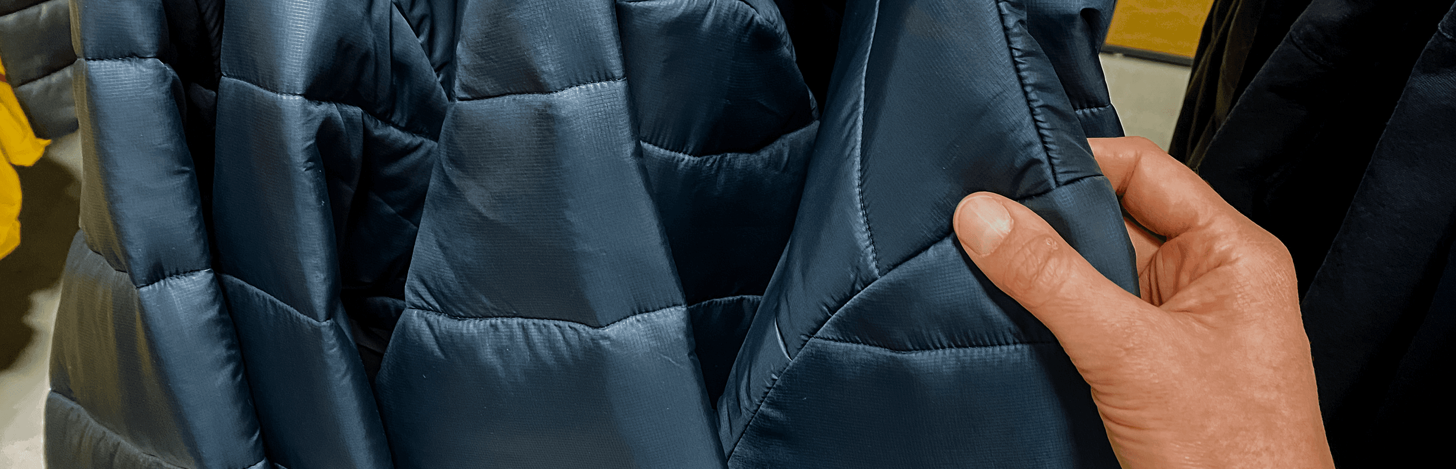 Checking the stitching on a quilted navy jacket panel